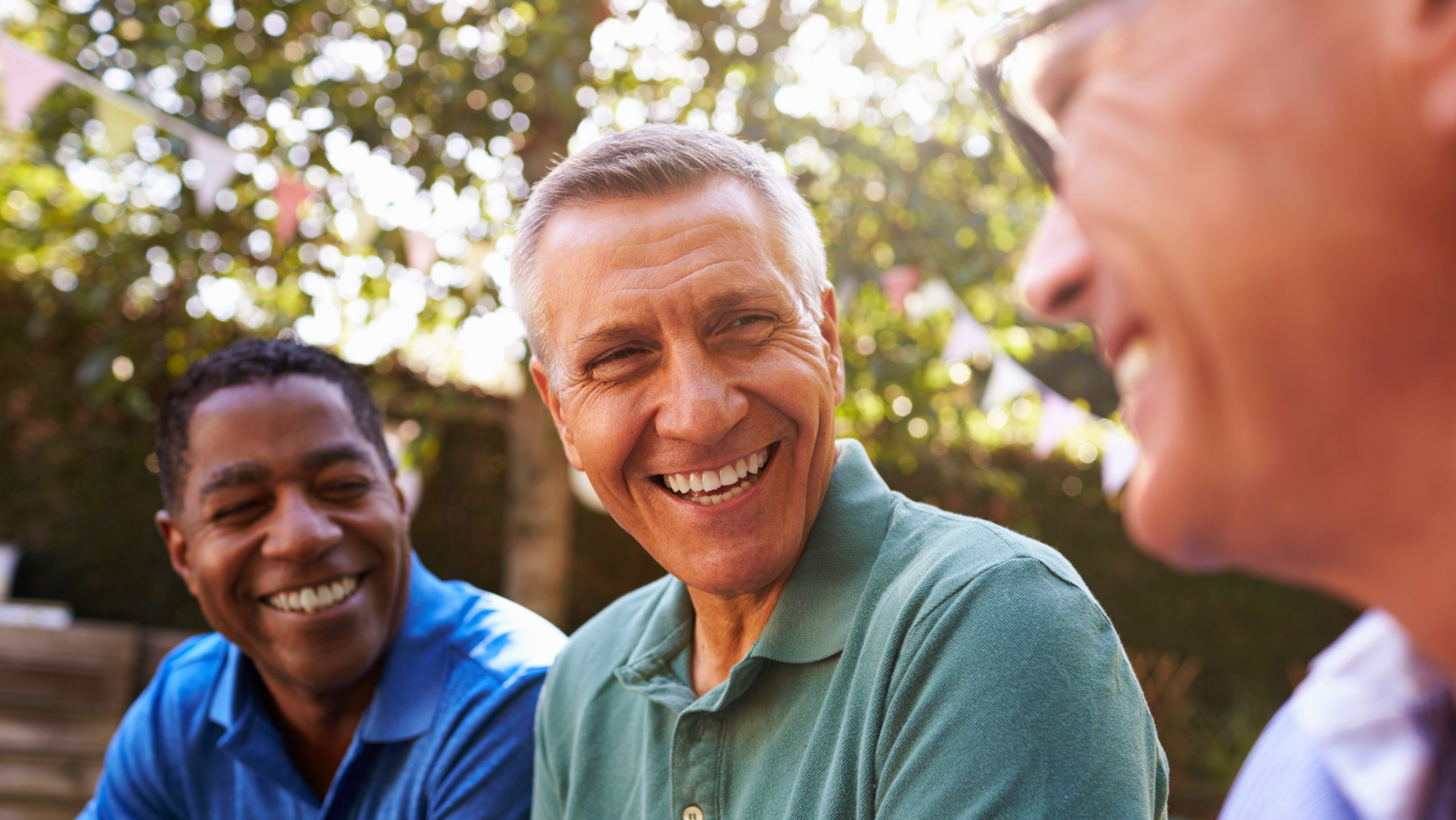 Mature Male Friends Socializing In Backyard Together