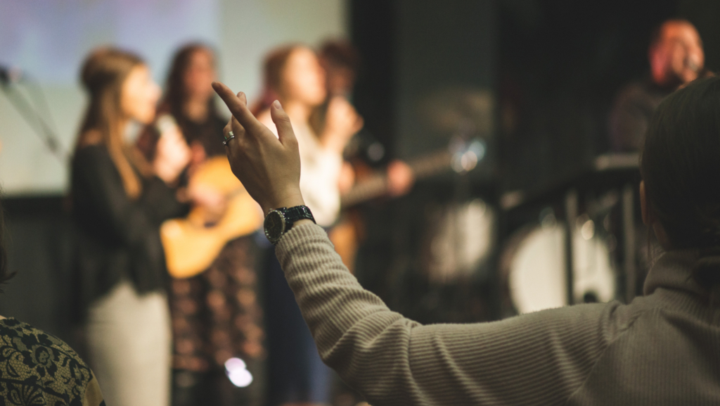Hands in the air of a woman who praise God at church service